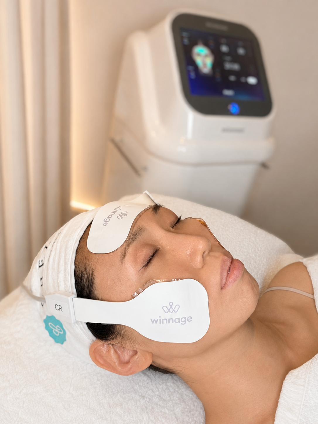 Winnage applicators positioned on a client's forehead and cheek during a session at Chez Moi de Beaute